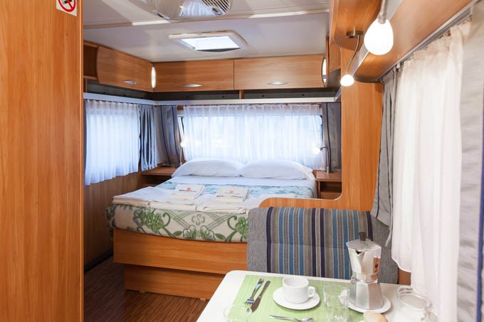 Glampingunterkunft: Wohnzimmer und Doppelbett - Caravan direkt am Meer auf Camping Ca' Pasquali Village
