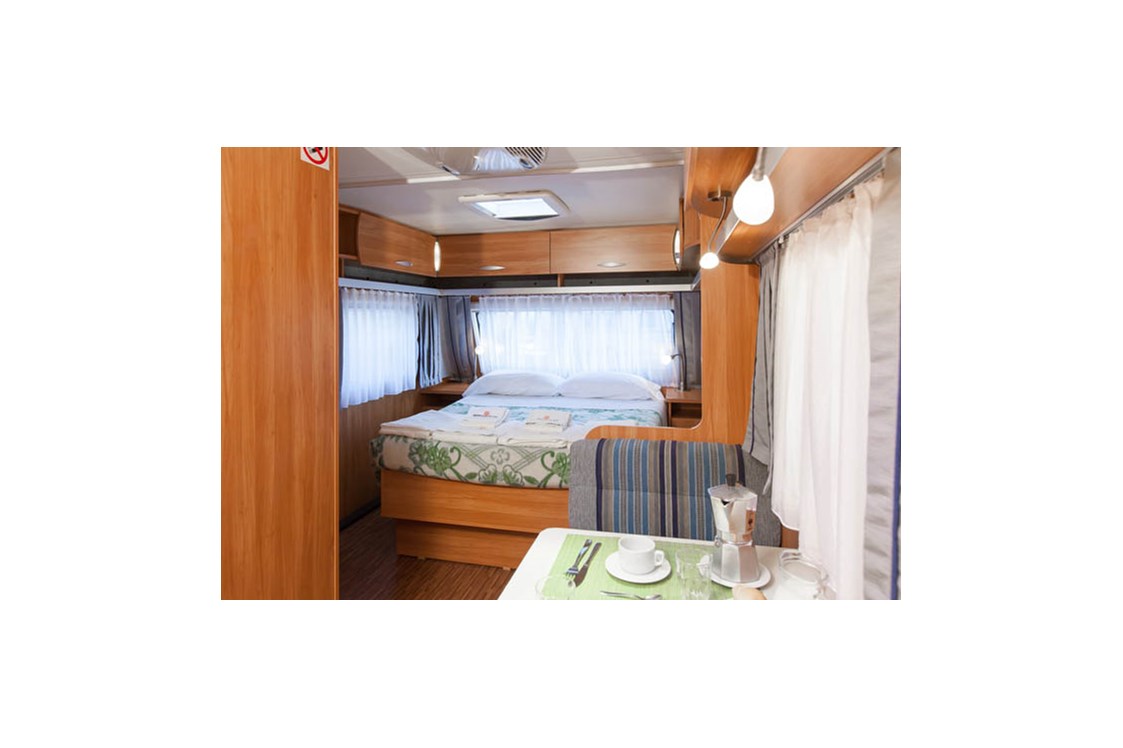 Glampingunterkunft: Wohnzimmer und Doppelbett - Caravan direkt am Meer auf Camping Ca' Pasquali Village