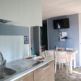 Glampingunterkunft: Wohnzimmer und Küche - Mobilheim Residence Platinum auf Camping Ca' Pasquali Village