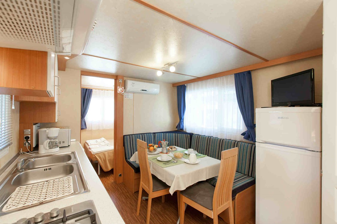 Glampingunterkunft: Wohnzimmer und Küchenzeile - Mobilheim Torcello Plus Gold auf Camping Ca' Pasquali Village
