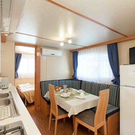 Glampingunterkunft: Wohnzimmer und Küchenzeile - Mobilheim Torcello Plus Gold auf Camping Ca' Pasquali Village
