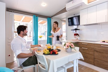Glampingunterkunft: Wohnzimmer und Küche - Mobilheim Laguna Platinum auf Camping Vela Blu