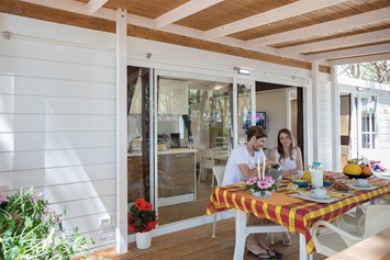 Glampingunterkunft: Außenansicht des Mobilheims mit Terrasse - Mobilheim Top Residence Platinum auf Camping Vela Blu