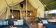 Luxuscamping - Tirol - Terrasse, Wohn-, Koch- und Essbereich Safari-Lodge-Zelt "Giraffe" - Safari-Lodge-Zelt "Giraffe" am Nature Resort Natterer See