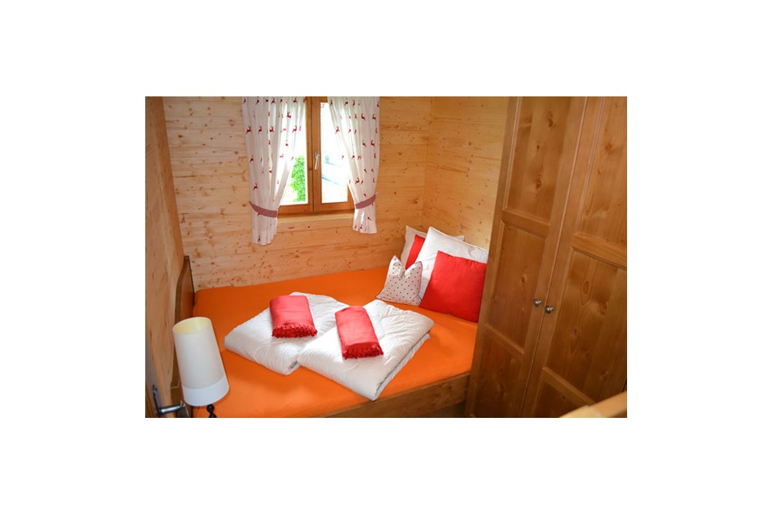 Glampingunterkunft: Ferienhütte "Schober": Schlafzimmer mit Doppelbett und einem Stockbett - Ferienhütten am CAMP MondSeeLand