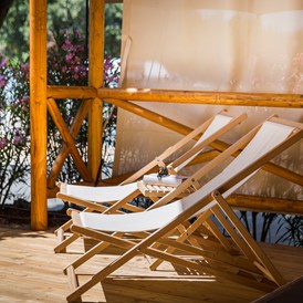 Glampingunterkunft: Große überdachte Terrasse mit zwei Sonnenliegen und Lounge-Sesseln - Safari-Zelte auf Krk Premium Camping Resort