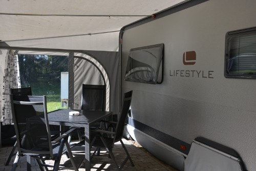 Glampingunterkunft: Selbstverständlich sind alle Mietwohnwagen mit Vorzelt und Campingtisch samt Stühlen ausgestattet. - Wohnwagen auf Naturcamping Malchow
