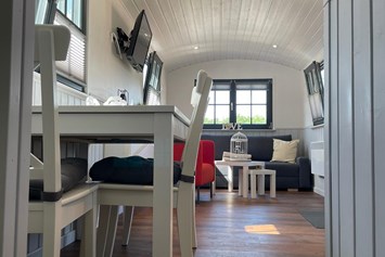 Glampingunterkunft: Gemütlicher Schäferwagen mit Doppelbett, Küchenzeile, Essbereich, Couch und eigener Toilette. - Campingpark Heidewald