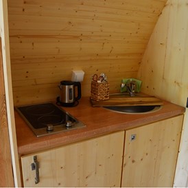 Glampingunterkunft: Küche mit Kochplatten, Spüle und Kühlschrank mit Eisfach - Glamping-Pod Waldemar am Wurlsee - Naturcampingpark Rehberge