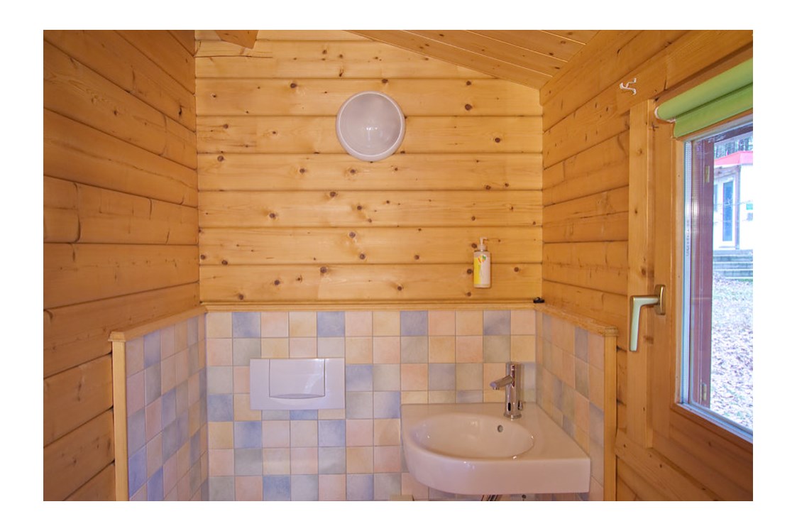 Glampingunterkunft: Bad mit Waschbecken und WC - Ferienhaus Rosalie am Wurlsee - Naturcampingpark Rehberge