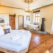 Luxuscamping: 1 Erkerschlafzimmer mit Doppelbett, freistehender Badewanne und einem Sofabett - Portenheim Suite Ansitz Camping Wildberg