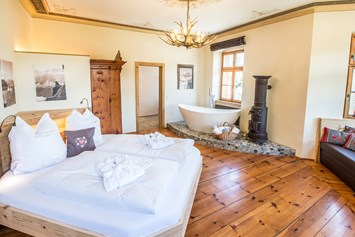 Glampingunterkunft: 1 Erkerschlafzimmer mit Doppelbett, freistehender Badewanne und einem Sofabett - Portenheim Suite Ansitz Camping Wildberg