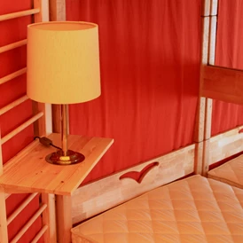 Glampingunterkunft: Jurte mit Lampe und liebevollen Details am Bett - Jurten auf dem Uhlenköper-Camp Uelzen