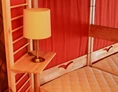 Glampingunterkunft: Jurte mit Lampe und liebevollen Details am Bett - Jurten auf dem Uhlenköper-Camp Uelzen