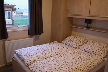 Glampingunterkunft: Schlafzimmer mit Doppelbett im Mobilheim "Ocala" - Mobilheime und Ferienhäuschen im Ostseecamping Ferienpark Zierow
