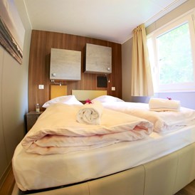 Glampingunterkunft: Doppelbett (Zimmer 1) mit WC und Dusche - Bungalow MIMOSA am Camping Tamaro Resort