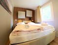 Glampingunterkunft: Doppelbett (Zimmer 1) mit WC und Dusche - Bungalow MIMOSA am Camping Tamaro Resort