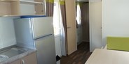 Luxuscamping - PLZ 3942 (Schweiz) - Die Mietunterkünfte sind ausgestattet mit Schlafzimmer (1 Bett: 140 x 200cm), Kinderzimmer (2 Betten: 80 x 200cm), Dusche/WC, Wohnküche mit SAT-TV und gedeckter Veranda mit Tisch und Stühlen. Pfannen, Besteck, Geschirr und Gläser, Bettdecken und Kopfkissen sind ebenfalls vorhanden. - Mobilheime am Camping Santa Monica