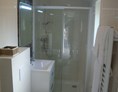 Glampingunterkunft: Badezimmer (gefliest) mit großzügiger Dusche, Waschbecken, WC und Handtuchwärmer - hochwertige Mobilheime in Kirchzarten / Schwarzwald