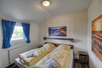 Glampingunterkunft: Eines der Schlafzimmer. - Ferienhaus Seeadler 5 Personen am Camping- und Ferienpark Wulfener Hals