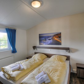 Glampingunterkunft: Eines der Schlafzimmer. - Ferienhaus Seeadler 5 Personen am Camping- und Ferienpark Wulfener Hals