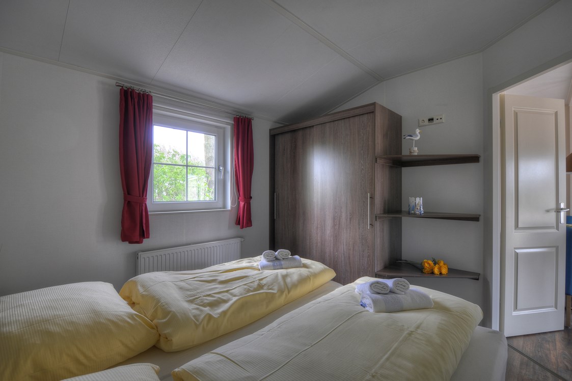 Glampingunterkunft: Das Schlafzimmer mit Doppelbett. - Ferienhaus Seemöwe 4 Personen am Camping- und Ferienpark Wulfener Hals