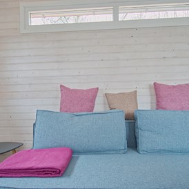 Glampingunterkunft: Sitzecke mit Couchtisch - Tiny House am See - Naturcampingpark Rehberge